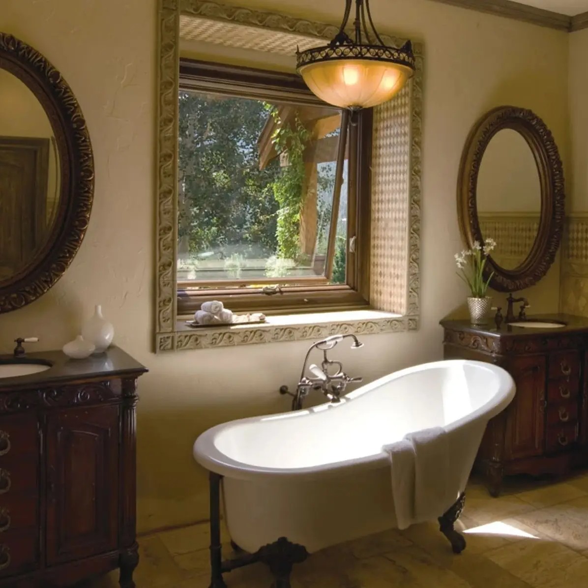 A bathroom with a clawfoot tub that is underneath a sandtone awning window, open for ventilation.