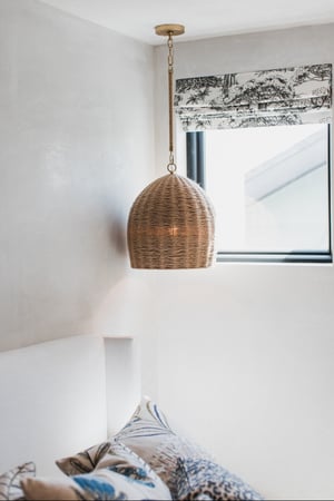 Breegan Jane's guest room with a picture window, rattan lamp, and fancy shades