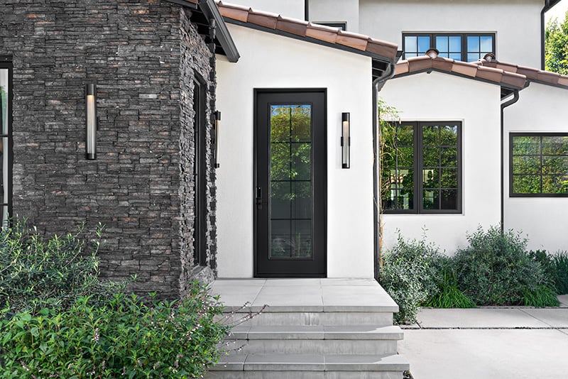 A white house featuring black trim and windows, showcasing a modern architectural design.